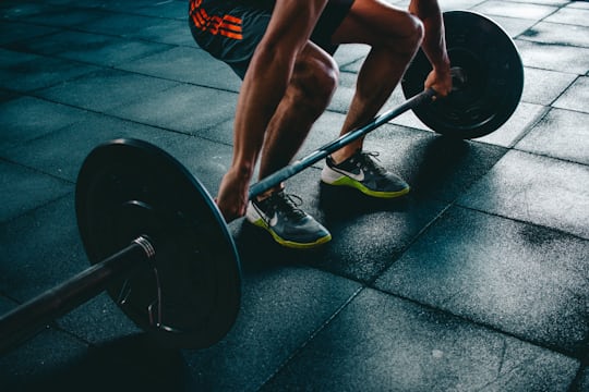 Person performing a barbell deadlift in a gym